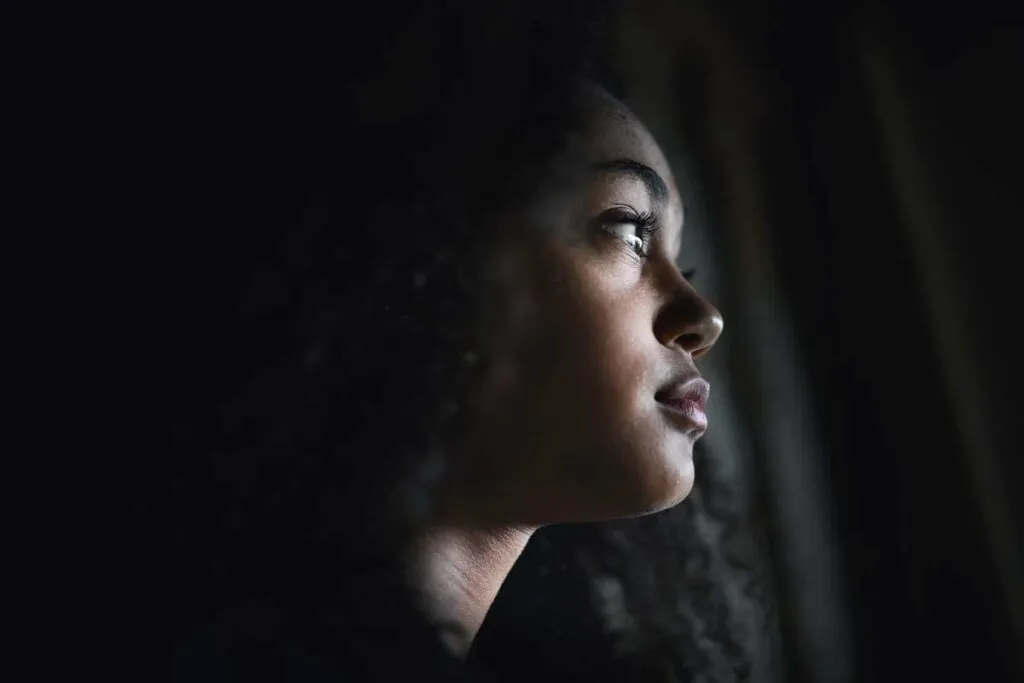 Image of a melancholic woman looking out the window, reflecting on the keyword 'I Miss My Ex', symbolizing post-breakup emotions and relationship regrets.